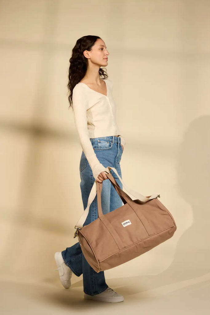 Sac week-end Gabriel couleur cannelle porté à la main par une femme